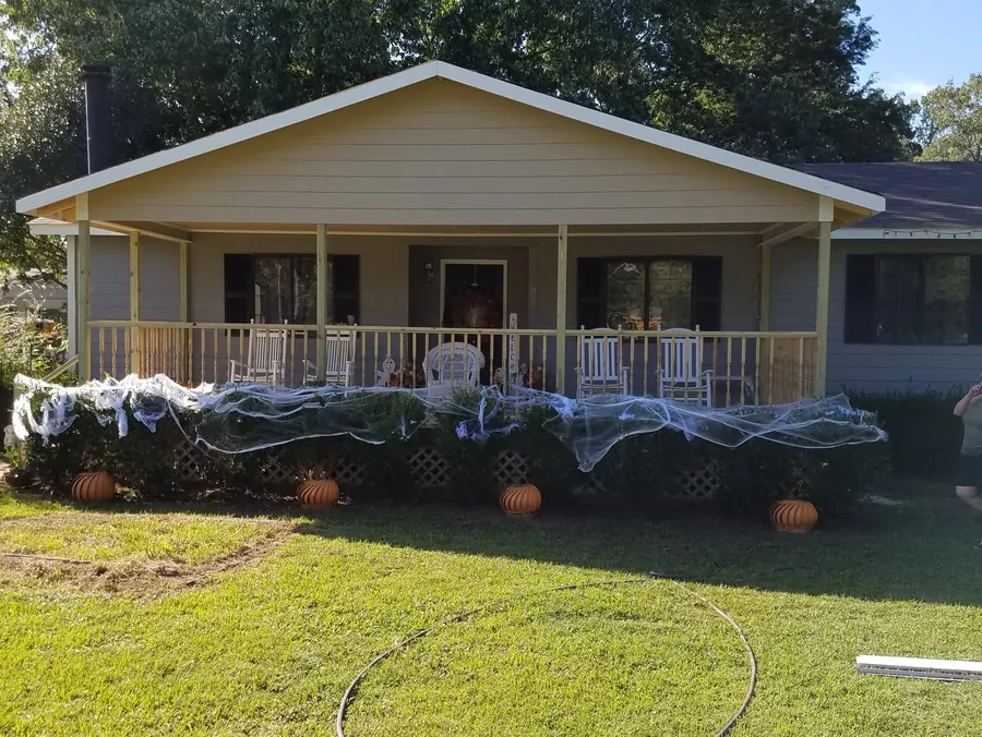 New gabled front porch addition with turned spindle railings and rocking chairs